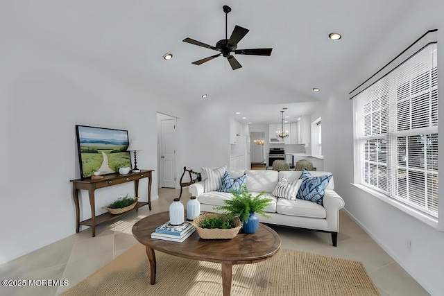 living area with light tile patterned floors, recessed lighting, and ceiling fan with notable chandelier