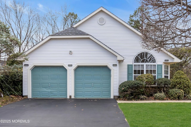 view of property exterior with an attached garage, driveway, and a shingled roof