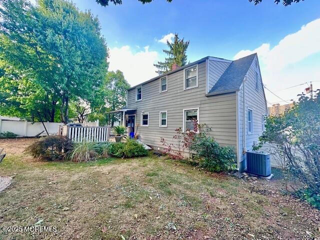 back of property with central air condition unit, fence, and a deck