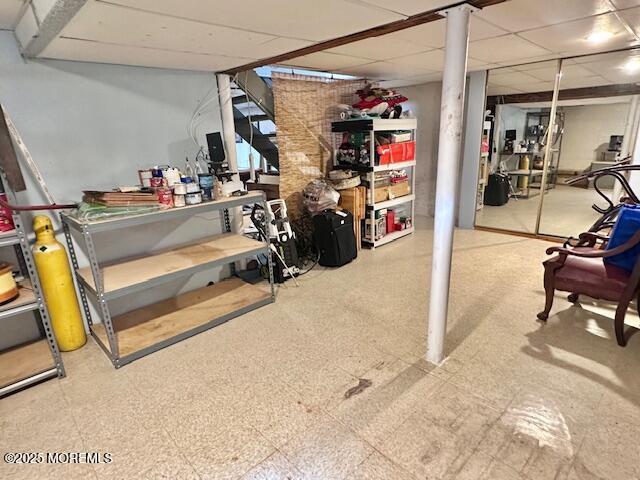 finished below grade area with a paneled ceiling and tile patterned floors