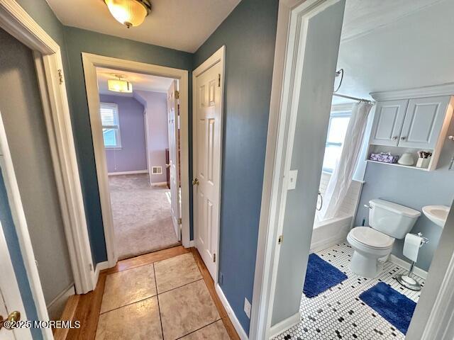 full bath featuring toilet, tile patterned flooring, shower / bath combo, and baseboards