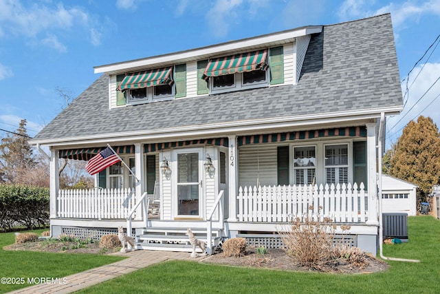 view of front of house featuring a shingled roof, a front yard, covered porch, and central AC unit