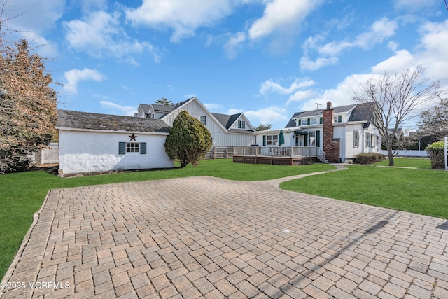 view of front of property with a wooden deck and a front lawn