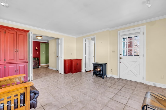 foyer with ornamental molding, a wood stove, baseboards, and light tile patterned floors