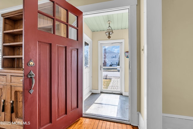 foyer with light wood-style floors and baseboards