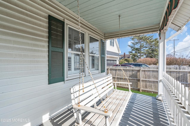 exterior space featuring covered porch and fence