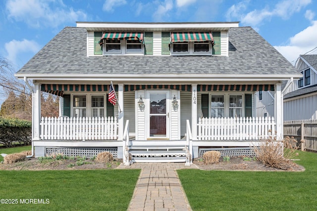 bungalow with covered porch, a shingled roof, and a front yard