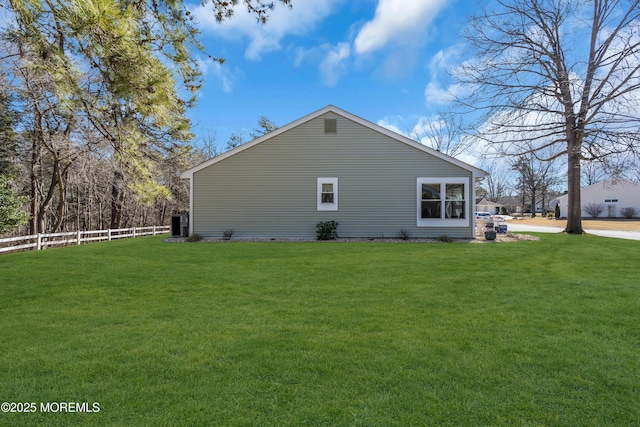 view of property exterior with a lawn and fence