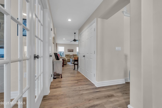 hall with light wood-style floors, recessed lighting, and baseboards