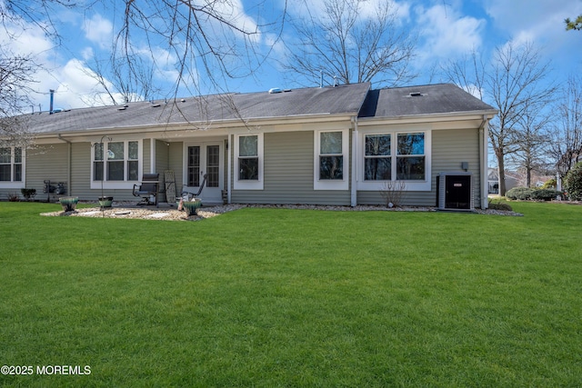 back of property with french doors and a lawn