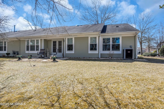 back of property with french doors, a lawn, and central air condition unit