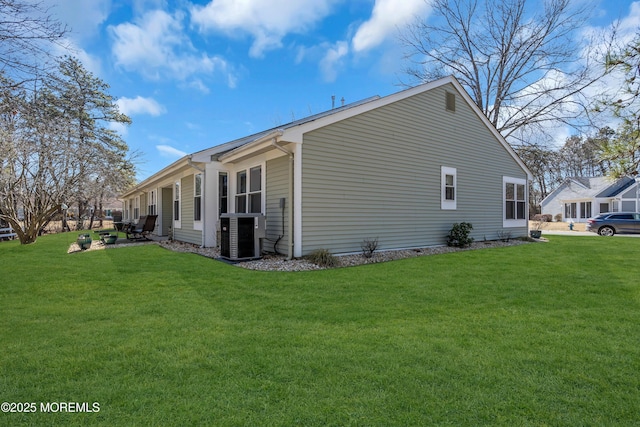 view of side of property with central air condition unit and a lawn