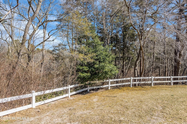 view of yard featuring fence and a view of trees