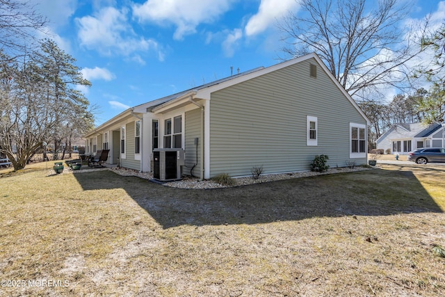 view of home's exterior with cooling unit and a yard