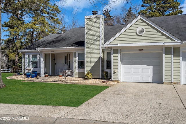 view of front of house with a front lawn, concrete driveway, a chimney, and an attached garage