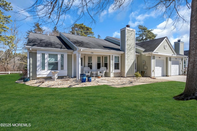 back of house featuring a garage, a chimney, a lawn, and concrete driveway