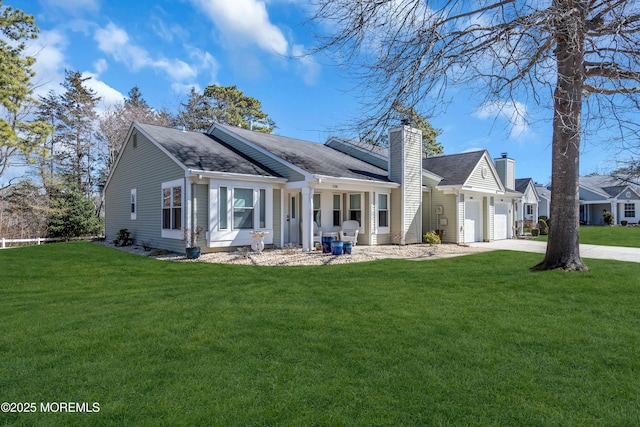 view of front of property featuring an attached garage, a chimney, a front lawn, and concrete driveway