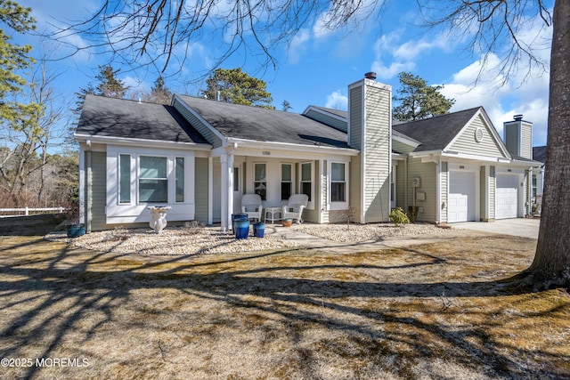 view of front of property featuring a garage, concrete driveway, and a chimney