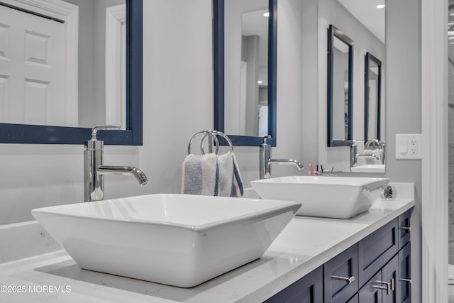 full bathroom with double vanity and a sink