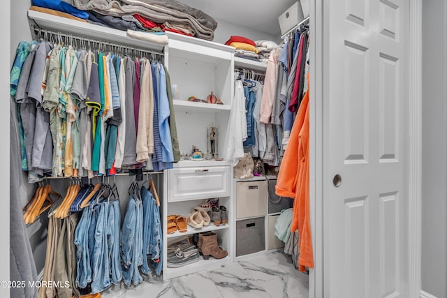 walk in closet featuring marble finish floor