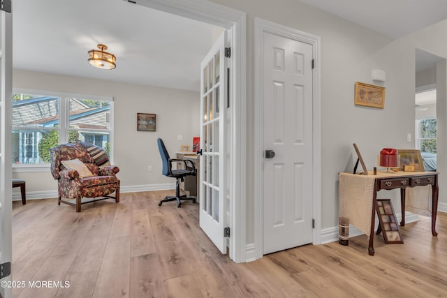 office area with baseboards, french doors, and light wood-style floors