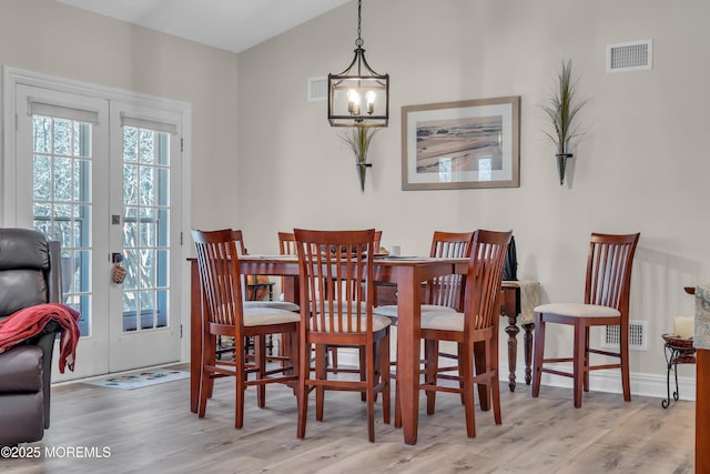 dining room featuring french doors, visible vents, and wood finished floors