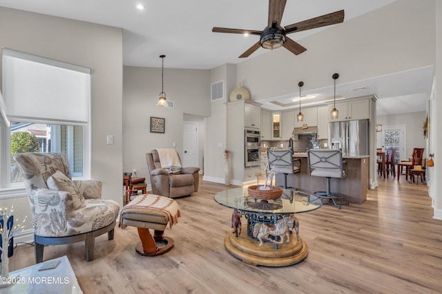 living room featuring light wood finished floors, recessed lighting, visible vents, and baseboards