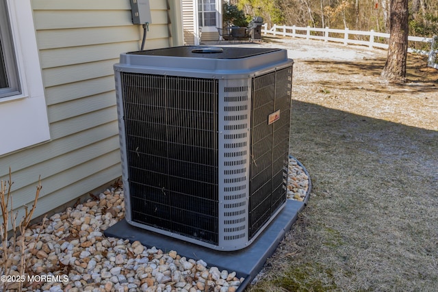 exterior details featuring central AC unit and fence