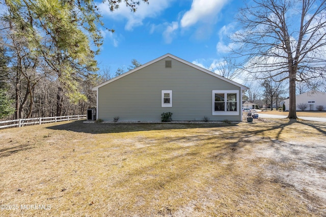 view of property exterior featuring fence and a yard