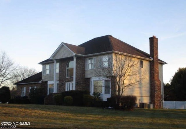 view of front of house with a front yard, fence, and a chimney