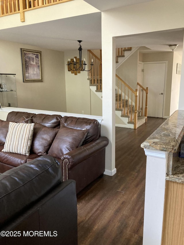 living room with stairs, baseboards, dark wood finished floors, and an inviting chandelier