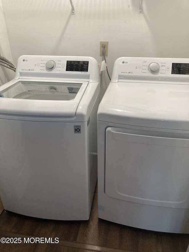 laundry room with dark wood-type flooring, laundry area, and separate washer and dryer