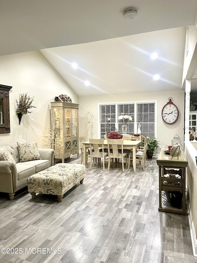 living room featuring high vaulted ceiling and wood finished floors