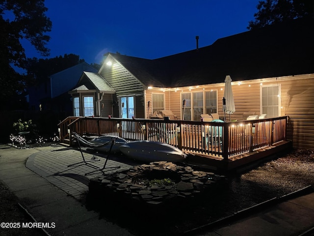 back of house at twilight with a wooden deck