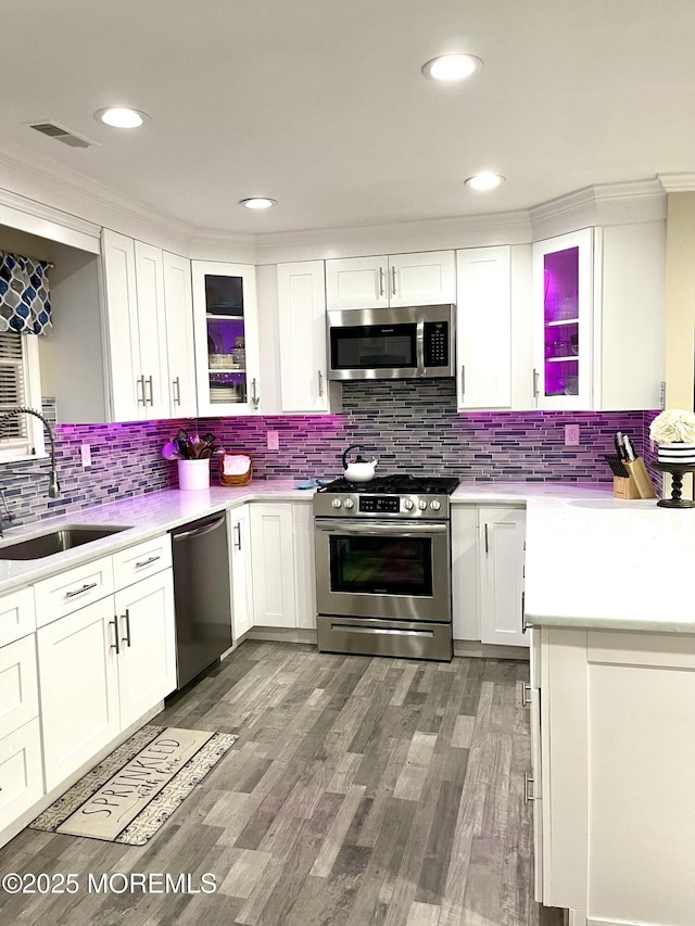 kitchen featuring a sink, stainless steel appliances, visible vents, and white cabinetry