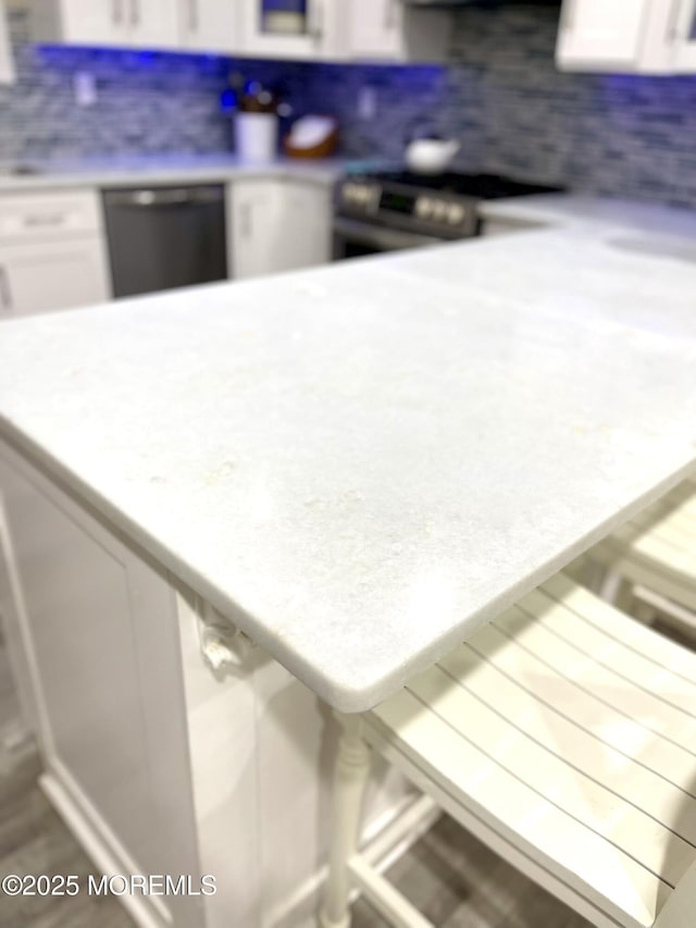 interior space featuring white cabinetry, dishwashing machine, and light countertops