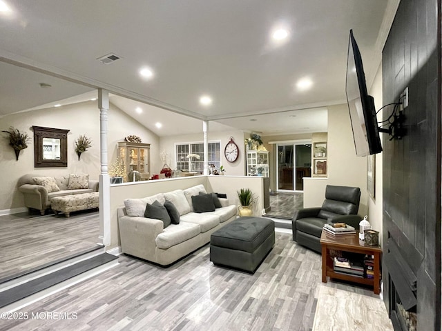 living room with light wood-type flooring, visible vents, recessed lighting, decorative columns, and vaulted ceiling