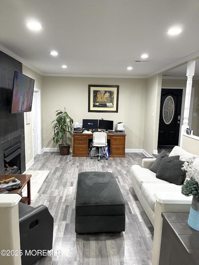 home office with baseboards, recessed lighting, a fireplace, light wood-style floors, and crown molding