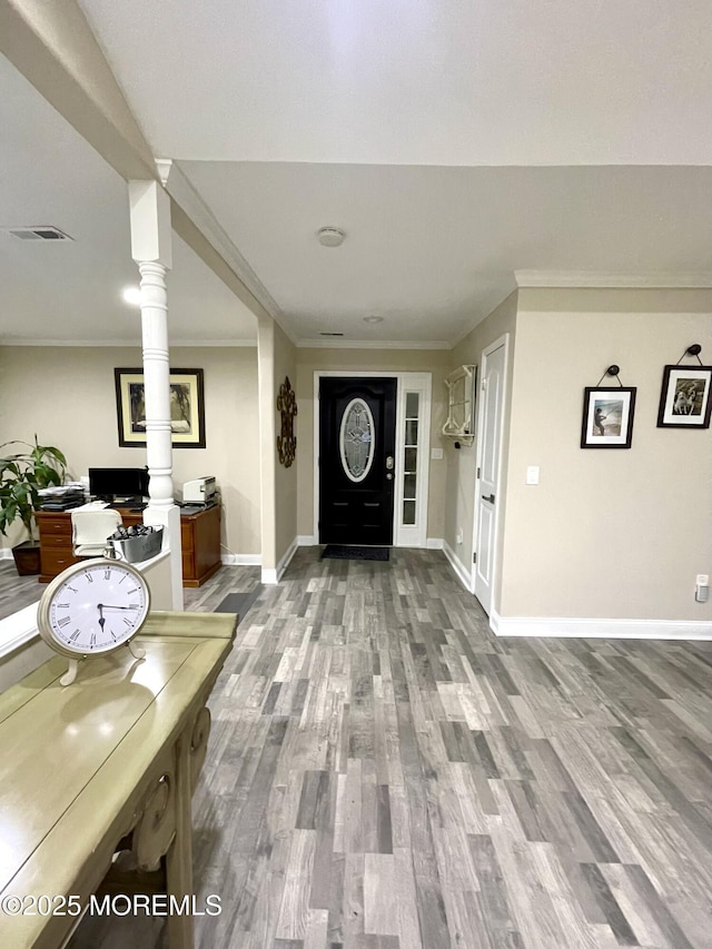 entrance foyer with visible vents, baseboards, wood finished floors, and ornamental molding