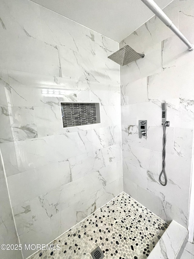 bathroom with visible vents and tiled shower