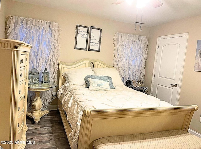 bedroom featuring visible vents, baseboards, wood finished floors, and a ceiling fan