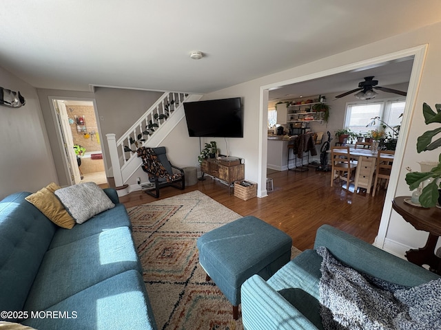 living room featuring stairs, wood finished floors, and a ceiling fan