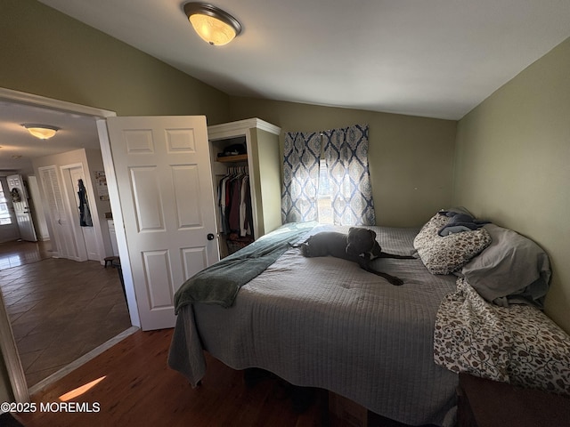 bedroom featuring lofted ceiling, a closet, and wood finished floors