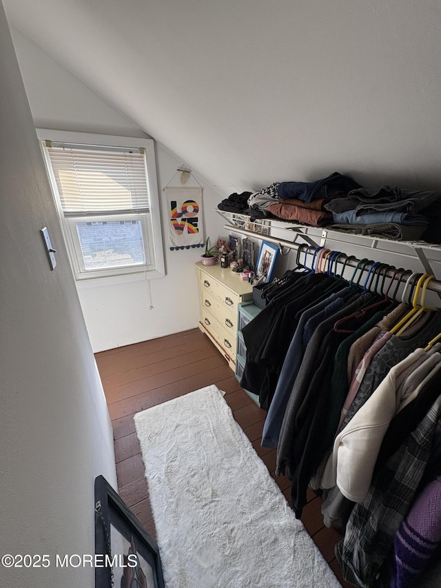 walk in closet with dark wood-style floors and vaulted ceiling