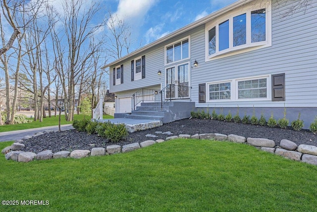 split foyer home with an attached garage and a front yard