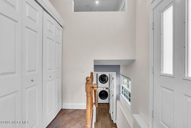 interior details featuring stacked washer and dryer and baseboards