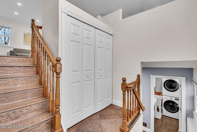 staircase with stacked washing maching and dryer, baseboards, and ornamental molding