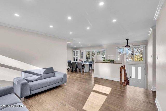 living room with ornamental molding, recessed lighting, and wood finished floors