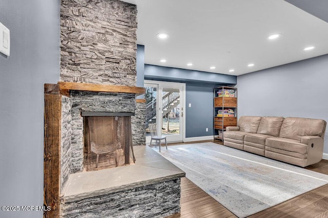 living area featuring a fireplace, baseboards, wood finished floors, and recessed lighting