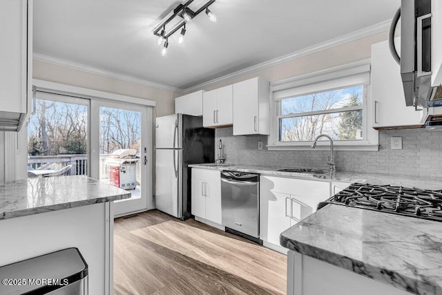 kitchen featuring appliances with stainless steel finishes, a sink, and ornamental molding